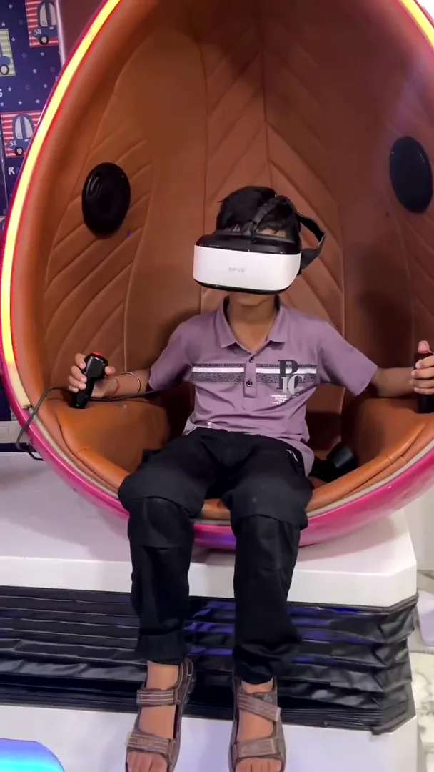 Child enjoying a virtual reality ride in a VR egg pod at Yey Kidzarea